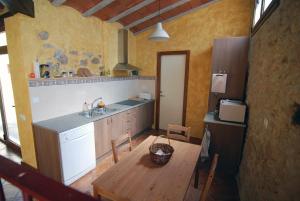 a kitchen with a table and a sink and a refrigerator at Ca lHorténsia in Rourell