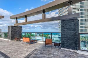 patio met stoelen en uitzicht op een gebouw bij Cambria Hotel Fort Lauderdale Beach in Fort Lauderdale