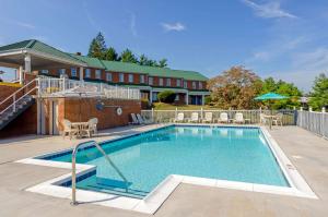 a swimming pool with chairs and a house at Quality Inn Waynesboro - Skyline Drive in Waynesboro