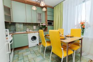 モスクワにあるLakshmi Apartment Belorusskyのキッチン、ダイニングルーム(テーブル、黄色い椅子付)