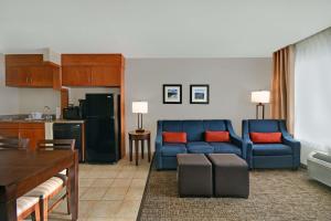 a living room with a blue couch and a kitchen at Comfort Inn & Suites Wilton in Wilton