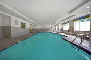 a swimming pool with blue water in a building at Comfort Inn & Suites Wilton in Wilton