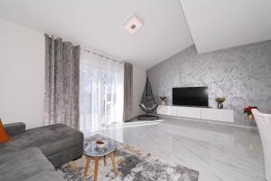 een woonkamer met een bank en een tv bij Apartman Chiara in Galovac