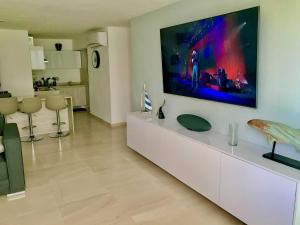 a living room with a large tv on the wall at Beautiful Apartment fully equipped AC 6 people 3 Bedrooms Wifi in Manzanillo