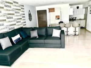 a green leather couch in a living room at Beautiful Apartment fully equipped AC 6 people 3 Bedrooms Wifi in Manzanillo