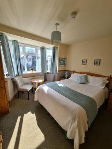 a bedroom with a large bed and a chair at Alington House in Cambridge