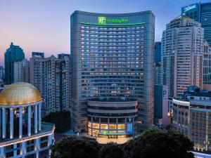 a tall building with a sign on the top of it at Holiday Inn Shanghai Nanjing Road by IHG in Shanghai