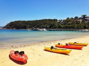 a group of three kayaks on a beach at Top Mosman Location in Sydney