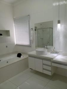 a white bathroom with a tub and a sink and a bath tub at Pousada São Francisco in São João Batista do Glória +66 photos