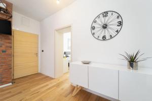 a white living room with a clock on the wall at Apartman Letifico in Split