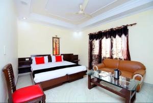 a bedroom with a bed and a couch and a table at Hotel Sanjog International in Amritsar