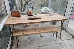 a wooden table with a tea kettle and a bench at Apartment near Brecon Beacons and Bike Park Wales in Bedlinog