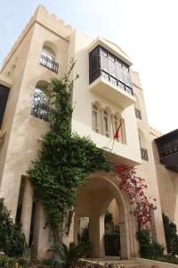 un edificio con un árbol delante de él en Borj Dhiafa, en Sfax