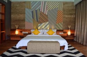 - une chambre avec un grand lit et des oreillers jaunes dans l'établissement TS SUITES Seminyak Bali, à Legian