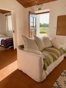 un sofá blanco en una sala de estar con ventana en Monte Da Moita Nova, en Cavaleiro