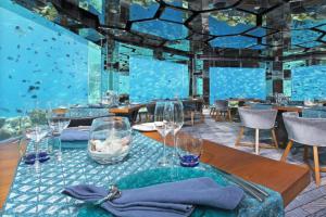 a room with an aquarium with a table and glasses at Durban Point Waterfront, 304 The Quays in Durban