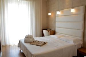 a bedroom with a white bed with towels on it at AmbientHotels Panoramic in Rimini