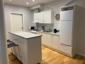 a kitchen with white cabinets and a white refrigerator at Gothersgade in Copenhagen +6 photos