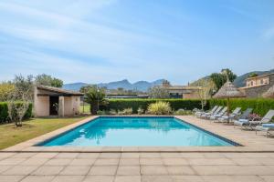 a swimming pool in a yard with lounge chairs at Villa Agnes in Pollença