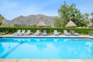 a swimming pool with chairs and umbrellas at Villa Agnes in Pollença