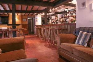 a bar with a row of stools in a restaurant at The Hawk & Buckle Inn in Llannefydd