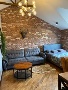 a living room with a couch and a brick wall at Апартаменты Три Стиля у Цветника in Pyatigorsk