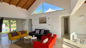 een woonkamer met oranje en zwarte meubels en een groot raam bij Galo by Check-in Portugal in Albufeira