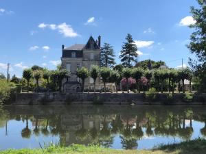 an old house reflected in the water of a lake at Stunning Chateau on the river bank in Saint Astier in Saint-Astier