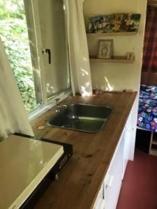 eine Küche mit einem Waschbecken auf einer hölzernen Arbeitsplatte in der Unterkunft Soulpath in Sint-Katelijne-Waver