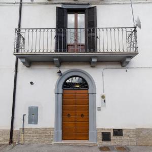 budynek z drewnianymi drzwiami i balkonem w obiekcie Casa Vacanze Gran Sasso w mieście Castel del Monte