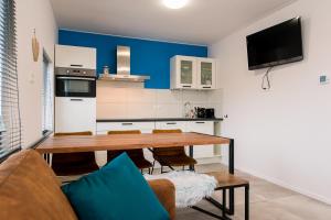 a kitchen and dining room with a wooden table at Onder de Pannen in Hollum
