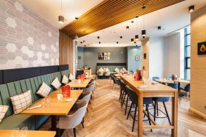 a dining room with wooden tables and chairs at Holiday Inn Bucharest - Times by IHG in Bucharest