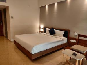 a bedroom with a large bed and a chair at VITS The Somnath Gateway in Somnath