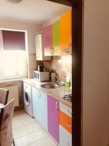 a kitchen with colorful cabinets and a sink at COLORFUL PARADISE in Piatra Neamţ