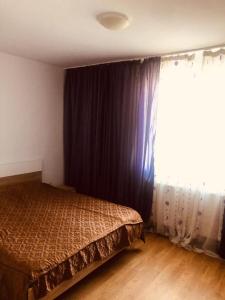 a bedroom with a bed and a large window at COLORFUL PARADISE in Piatra Neamţ