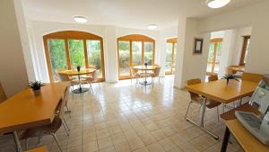 a room with tables and chairs and windows at Delémont Youth Hostel in Delémont