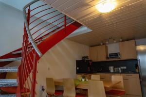 a room with a staircase and a table and a kitchen at Gästehaus Familie John in Veitsbronn