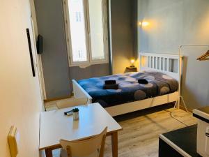 um pequeno quarto com uma cama e uma mesa em Mirabeau Studio em Aix-en-Provence