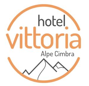un cartello per un hotel in un cerchio con le montagne di Hotel Vittoria a Folgaria