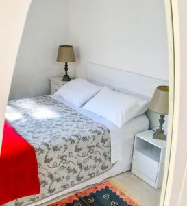 um pequeno quarto com uma cama e uma mesa de cabeceira em Floripa Hostel em Florianópolis