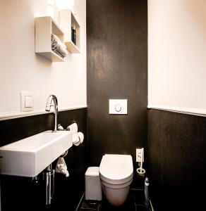 uma casa de banho com um lavatório branco e um WC. em Sealinda em Oostende
