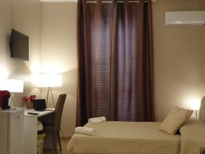 a bedroom with a bed and a desk and a window at Oasi Iblea Inn in Ragusa