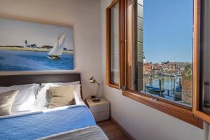 a bedroom with a bed and a large window at Sea to Sky Apartments in Venice