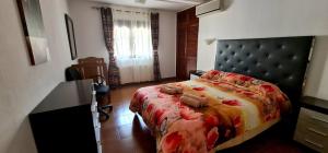a bedroom with a bed with a red floral bedspread at Villa Las Adelfas (escapada ideal en Costa Blanca) in Calpe +24 photos
