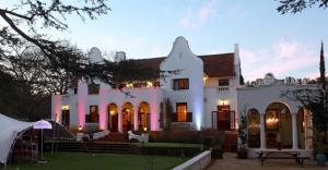 ein großes weißes Haus mit einem Hof in der Unterkunft Le Jardin Villa in Stellenbosch