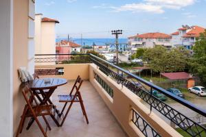 balcón con mesa, sillas y vistas al océano en Dimitria, en Leptokarya