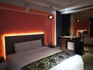 una camera con letto e parete rossa di Love Story Motel a Taipei