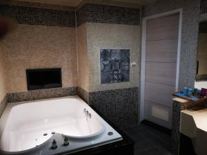 a bathroom with a tub with a tv and a television at Love Story Motel in Taipei