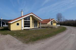 una casa amarilla al lado de un camino de tierra en Resort 1 Ocean Cottage A 147 en Großenbrode