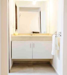 a white bathroom with a sink and a mirror at Genetrix 10 - Bon Repos in San Miguel de Tucumán